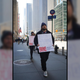 Two strikers walk the picket line outside an office building, carrying signs.
